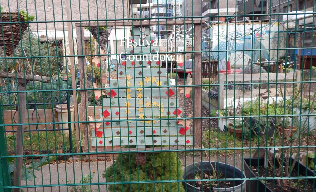 an image of a wooden christmas tree behind a fence