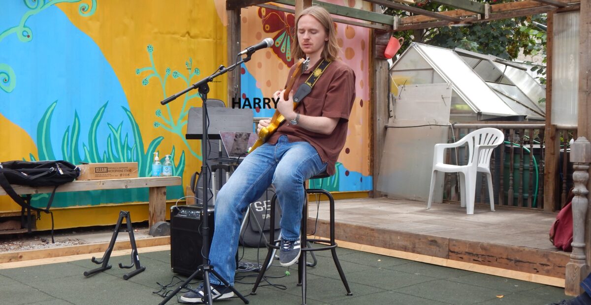 image of Harry Demmon playing guitar in the garden