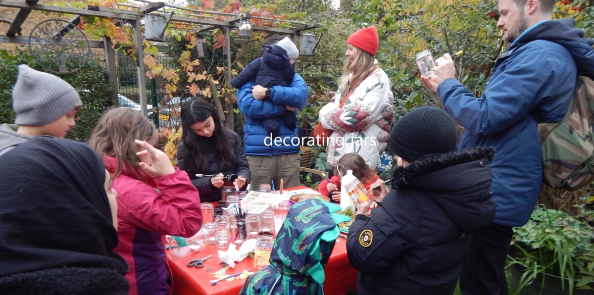 image of people decorating jars for candles in the garden